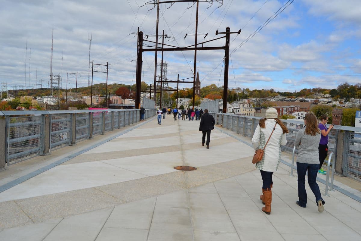 Opening day on the Manayunk Bridge Trail, October 2015: people walking the new deck between the railings, under the old catenary frames.